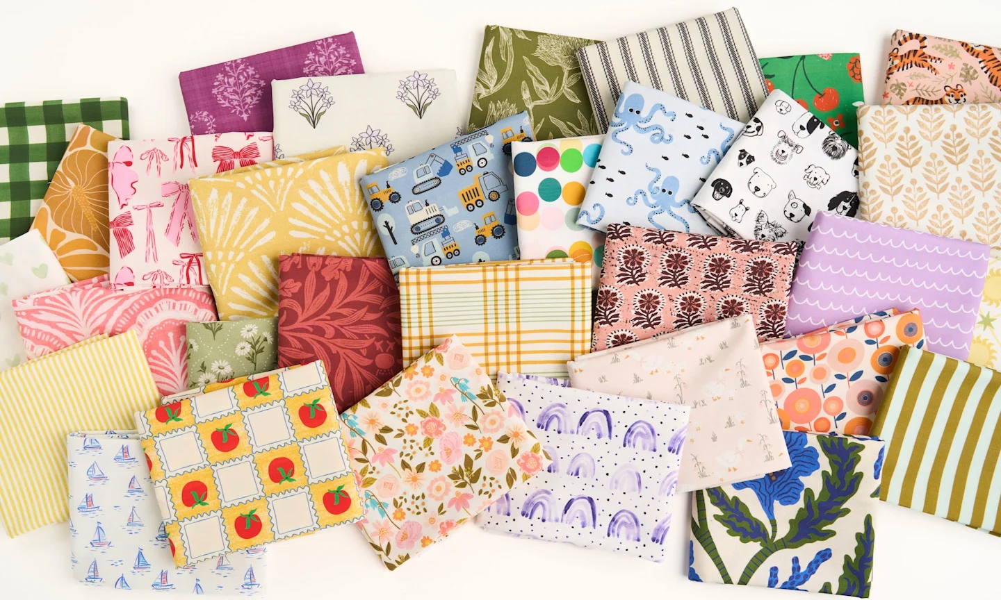 many colorful fold up pieces of fabric laying on a table