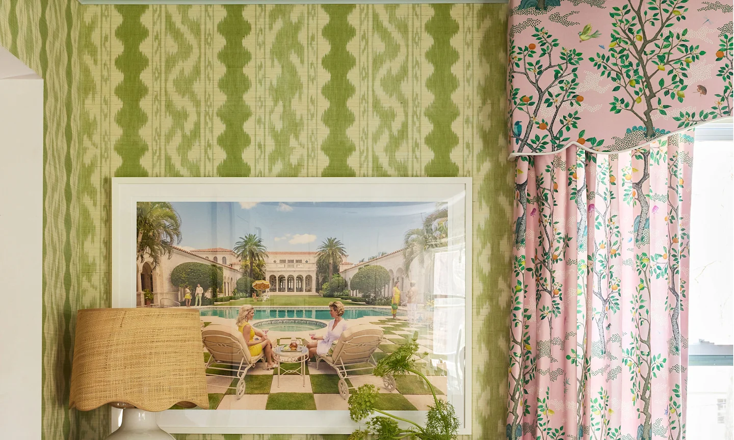 Wall with green wallpaper and pink curtains around a window.