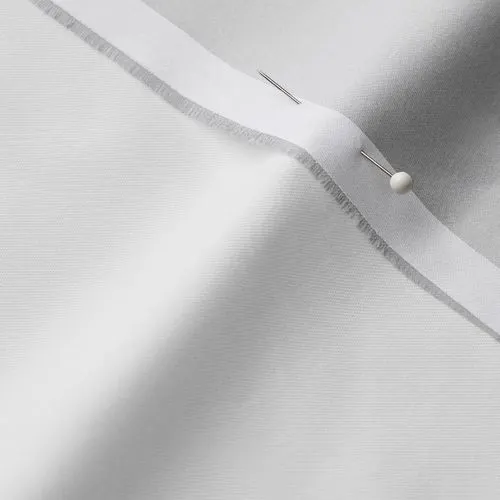 A close-up photo of white fabric with a pin running through it