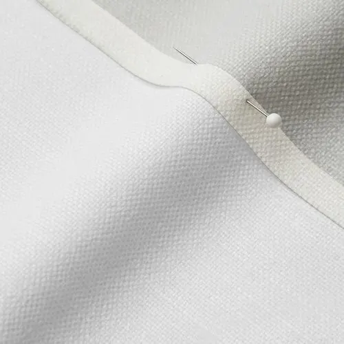 A close-up photo of white fabric with a pin running through it